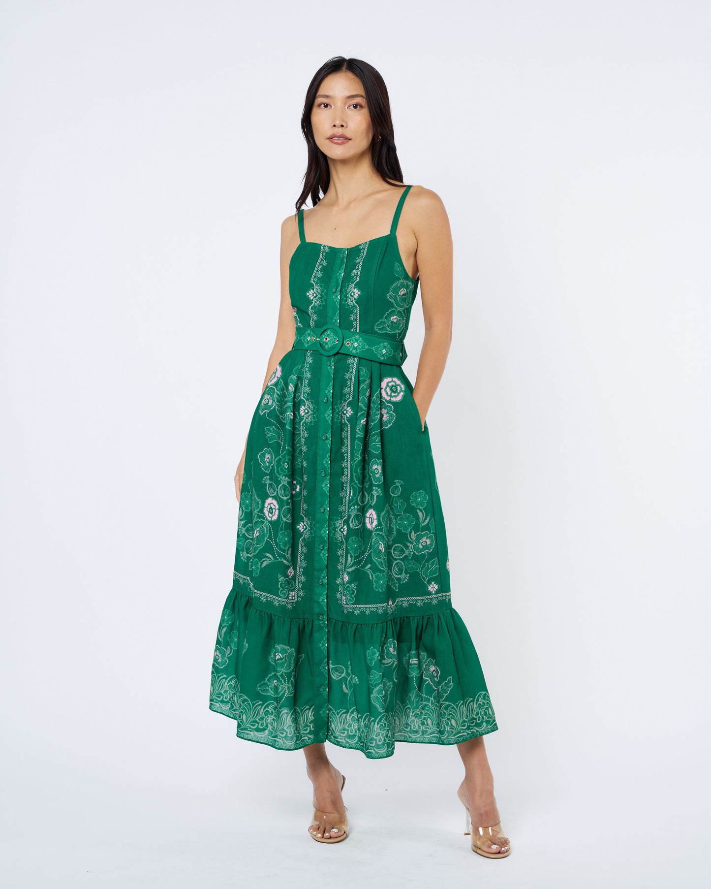 Woman wearing a green floral dress on a white background