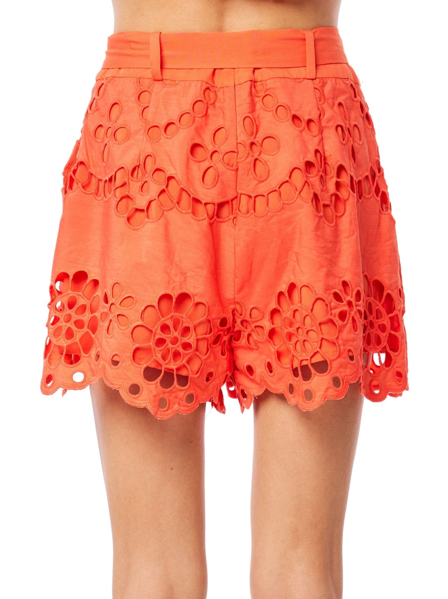 Person wearing a bright orange lace skirt on a white background