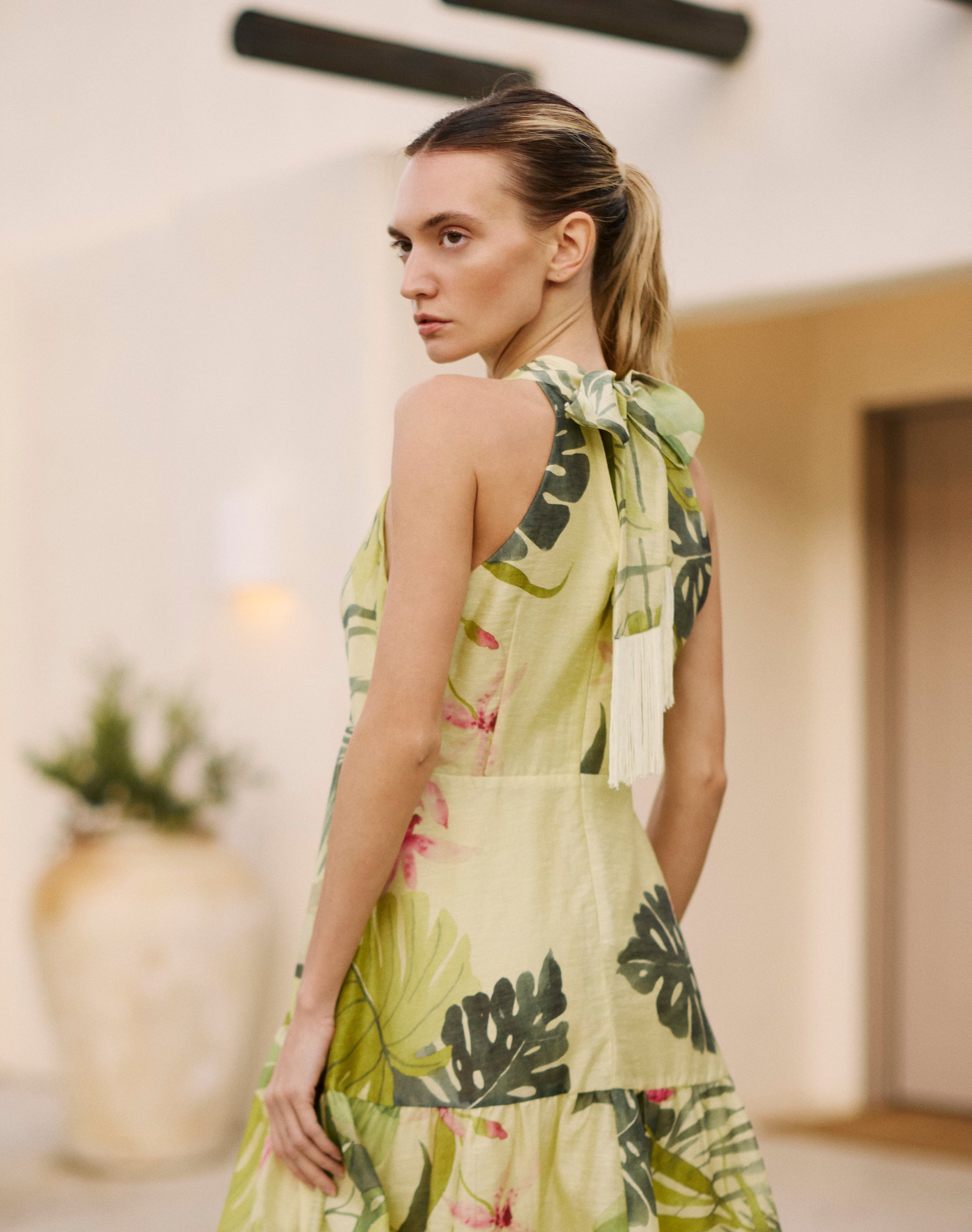 Woman wearing a green floral dress in an indoor setting
