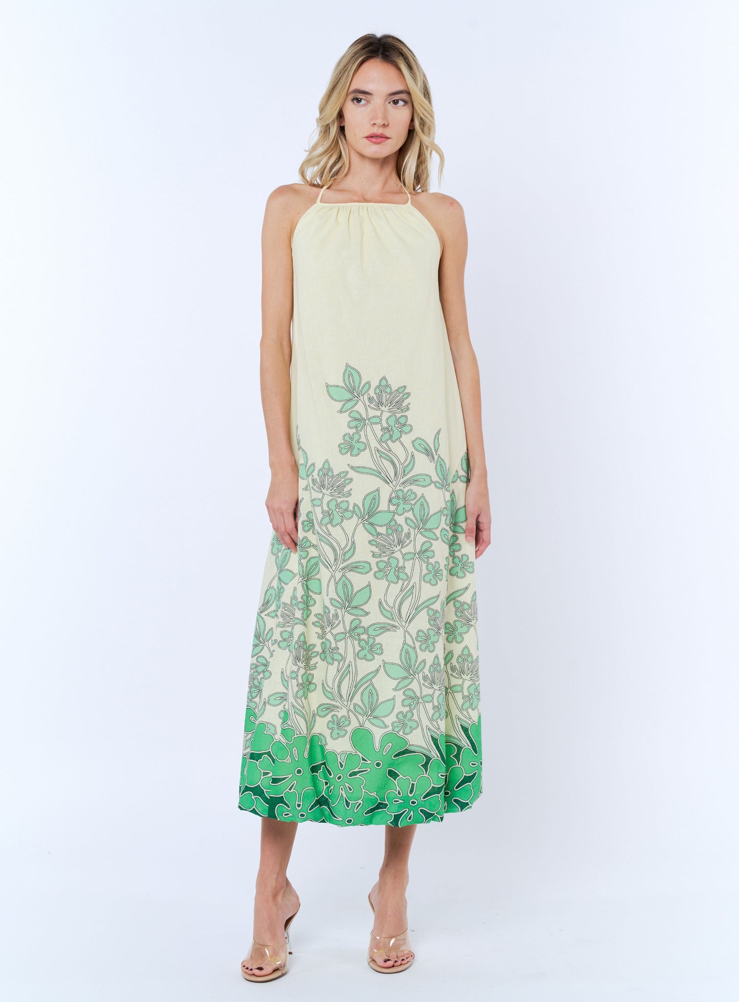 Woman wearing a green and white floral dress on a white background