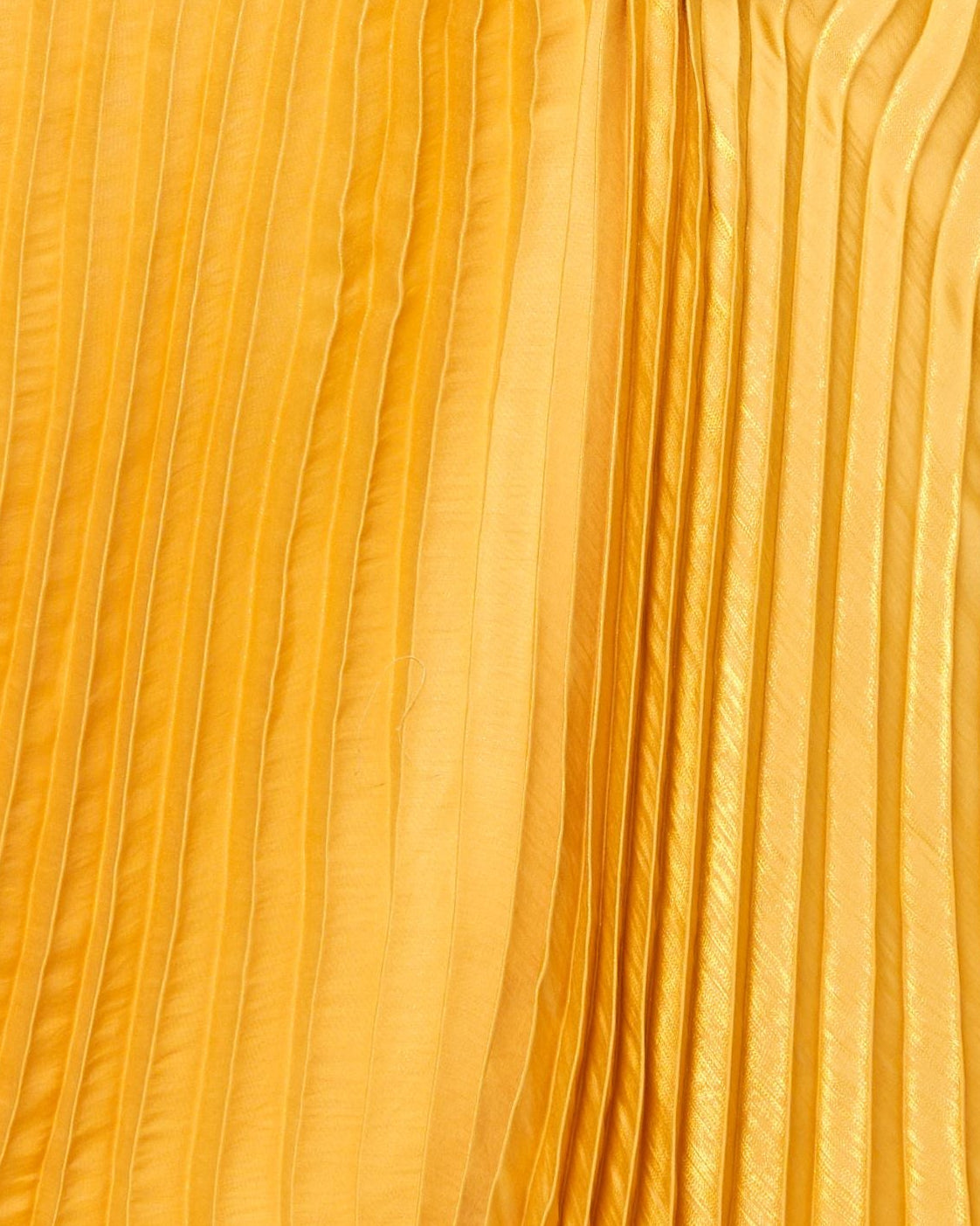 Woman wearing a yellow pleated dress on a white background
