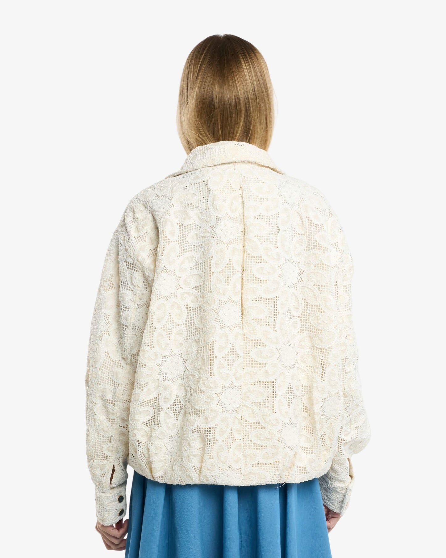 Person wearing a white sweater and blue skirt on a white background