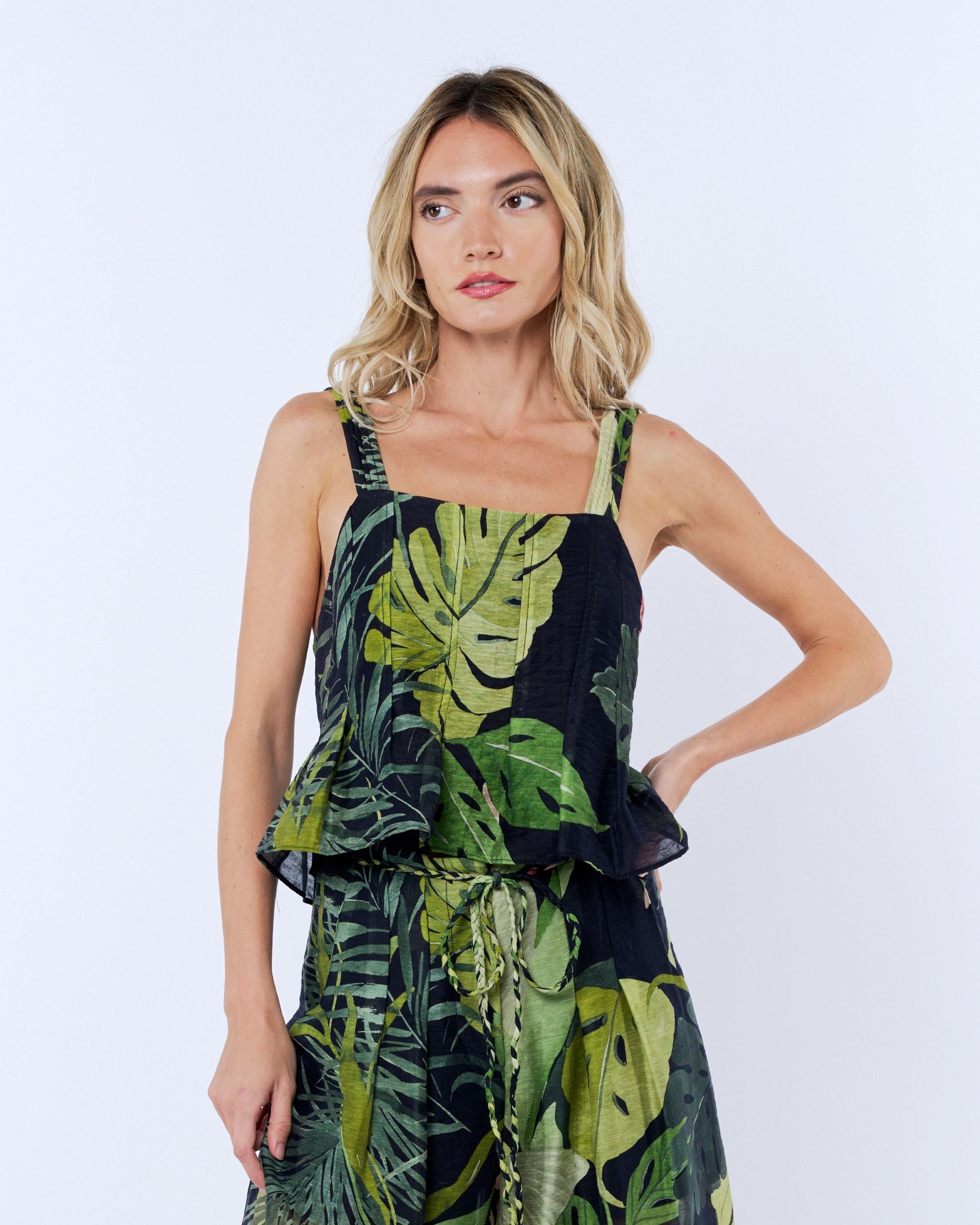 Woman wearing a tropical print dress on a white background