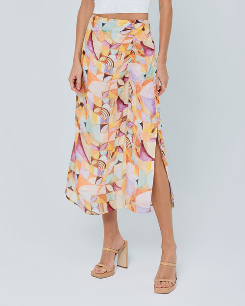 Load image 1 in gallery view. Woman wearing a white top and colorful abstract patterned skirt on a plain background