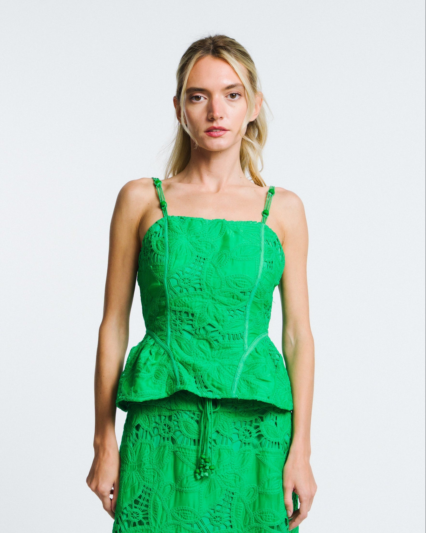 Woman wearing a green lace dress on a white background