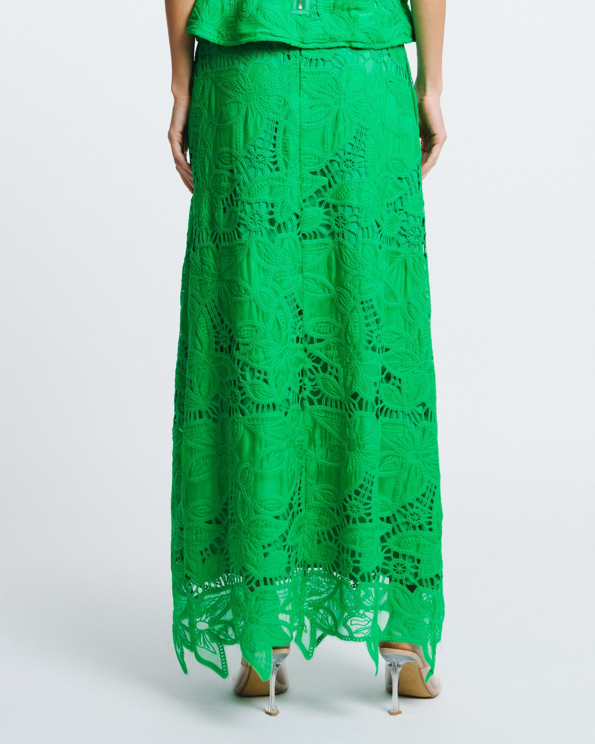 Woman wearing a green lace dress on a white background
