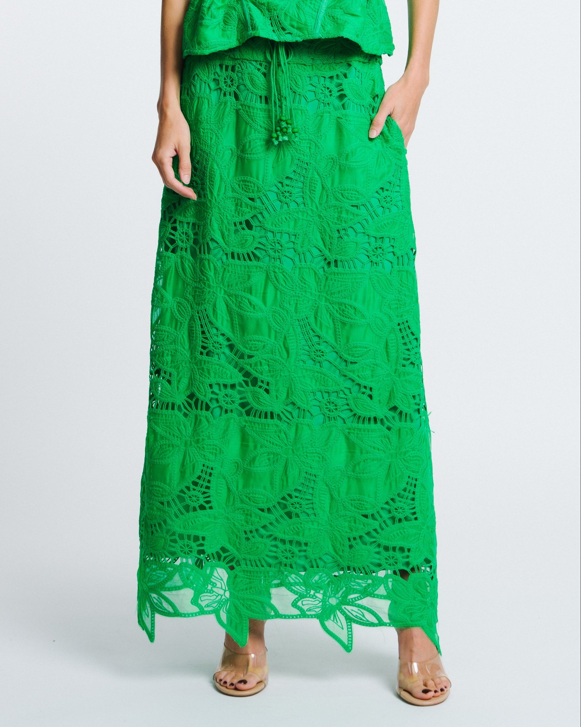 Woman wearing a green lace dress on a white background