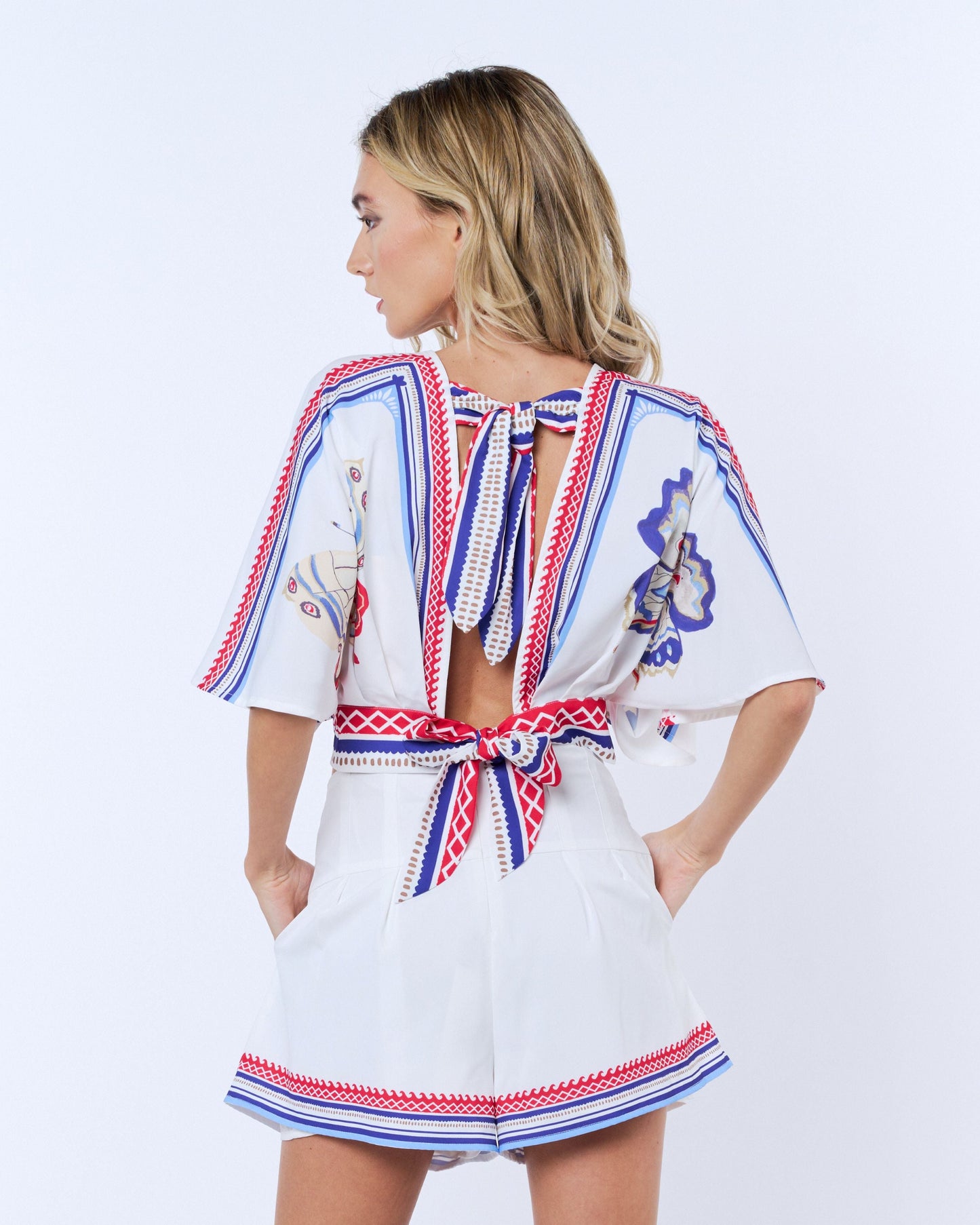 Woman wearing a white dress with colorful patterns on a white background
