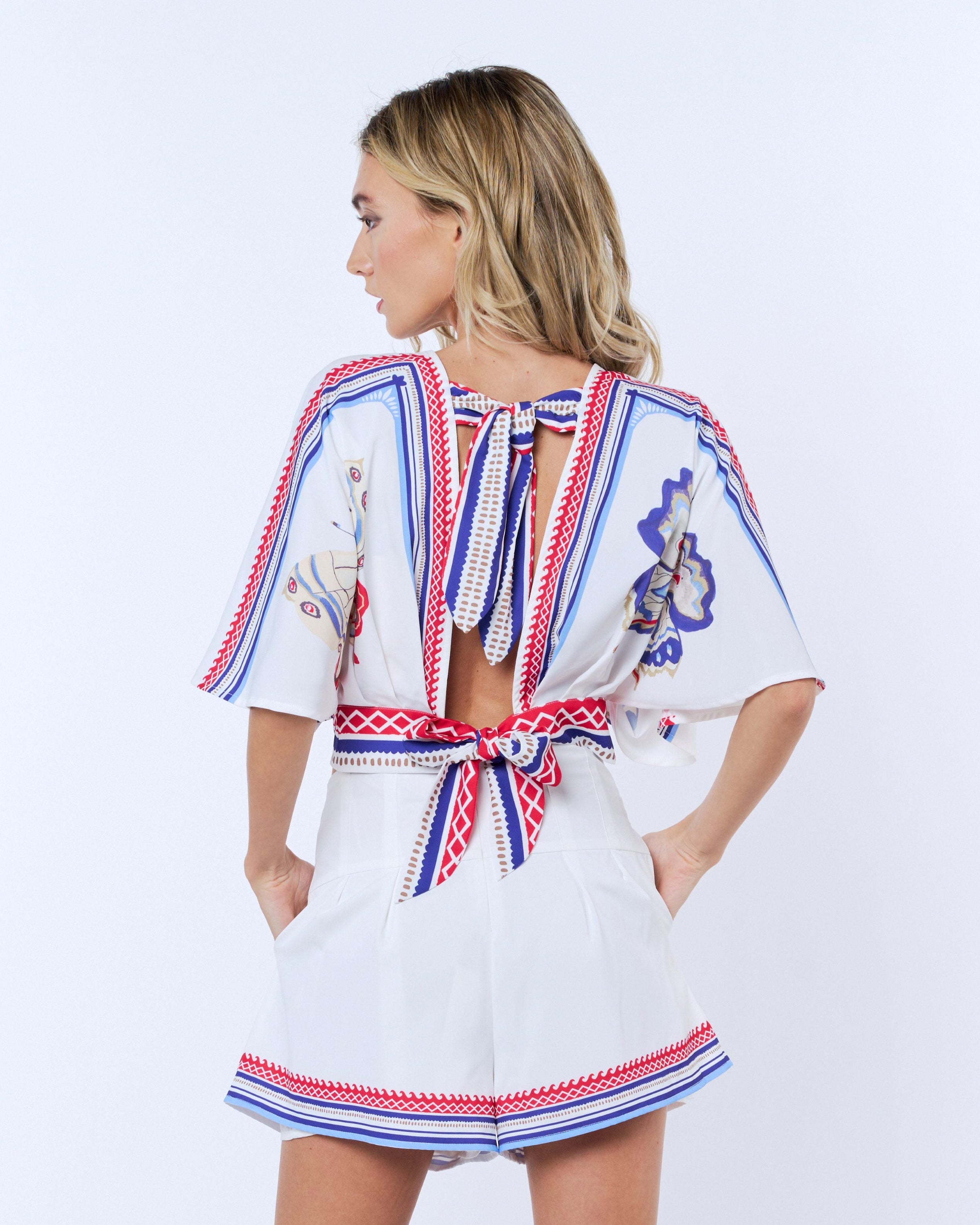 Woman wearing a white dress with colorful patterns on a white background