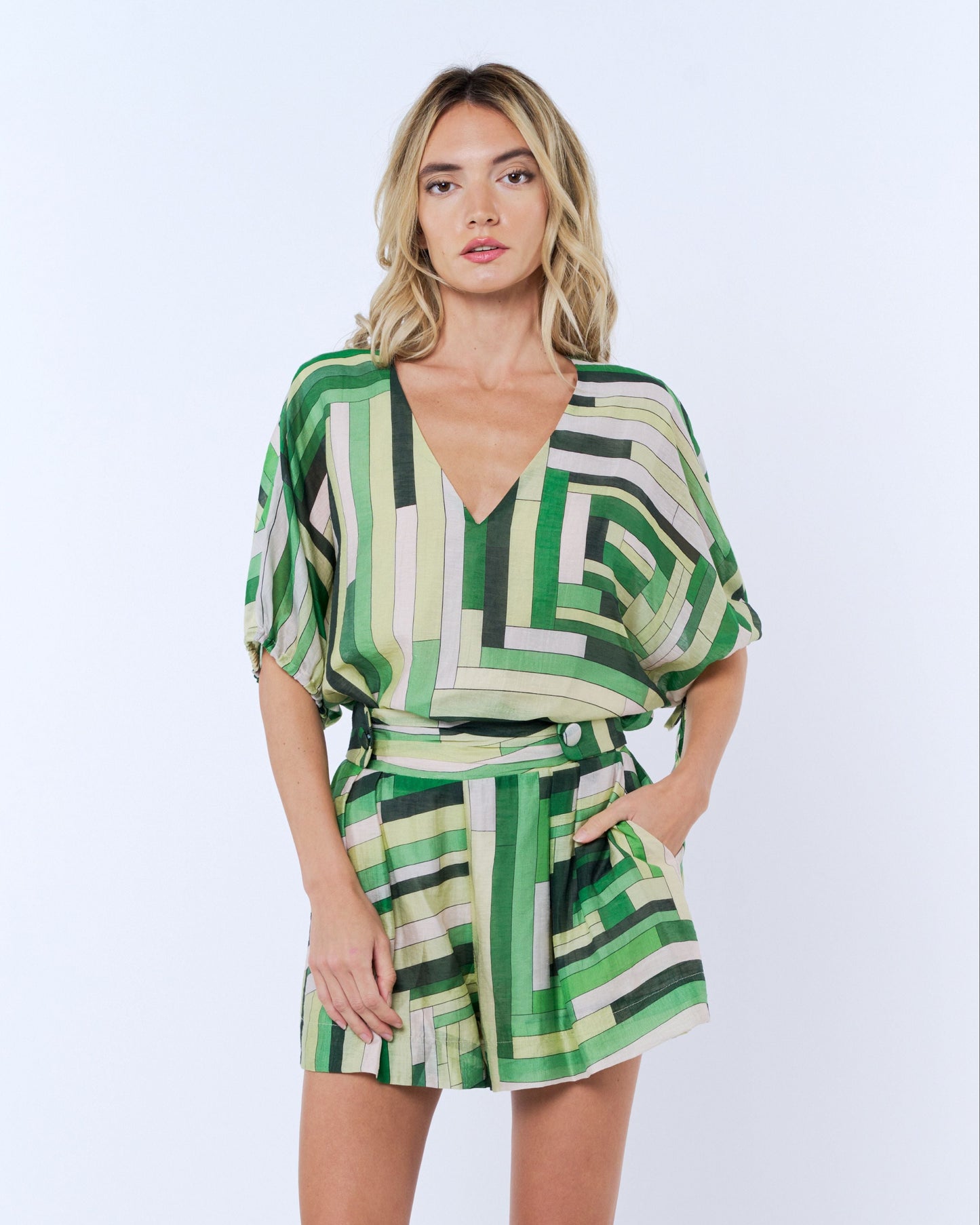 Woman wearing a green geometric patterned dress on a white background
