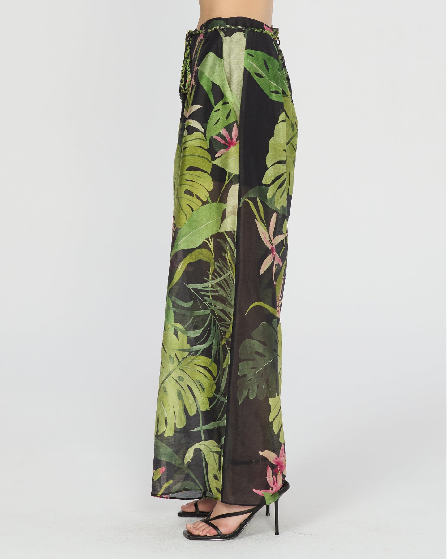 Person wearing a tropical leaf patterned outfit on a white background