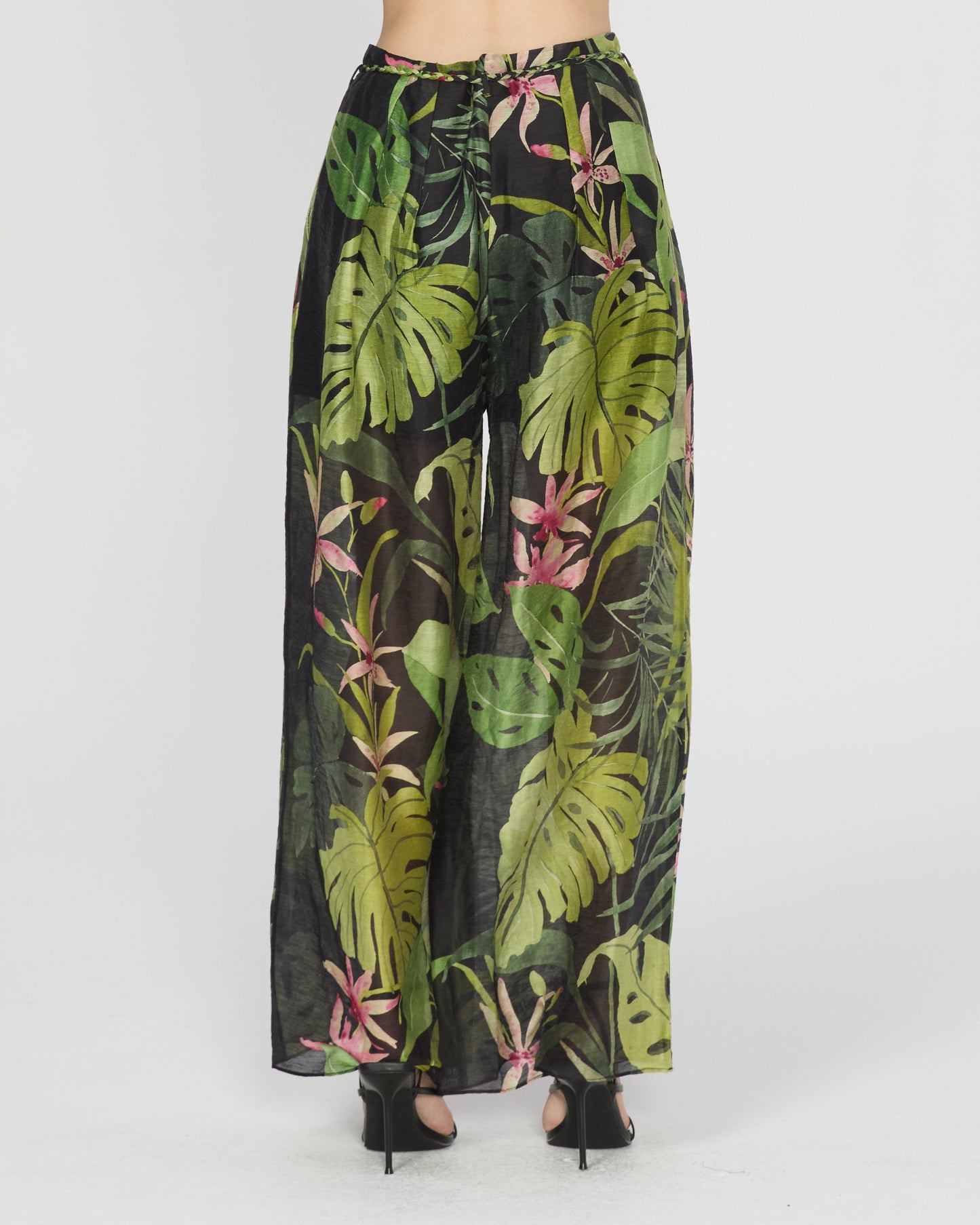 Person wearing a tropical leaf patterned outfit on a white background
