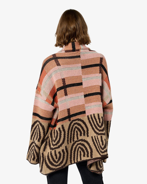 Load image 1 in gallery view. Person wearing a patterned sweater and black pants on a white background