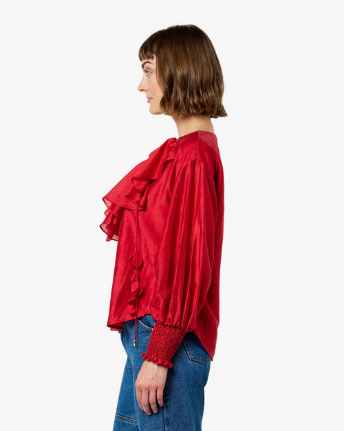 Load image 1 in gallery view. Woman wearing a red blouse and blue jeans on a white background